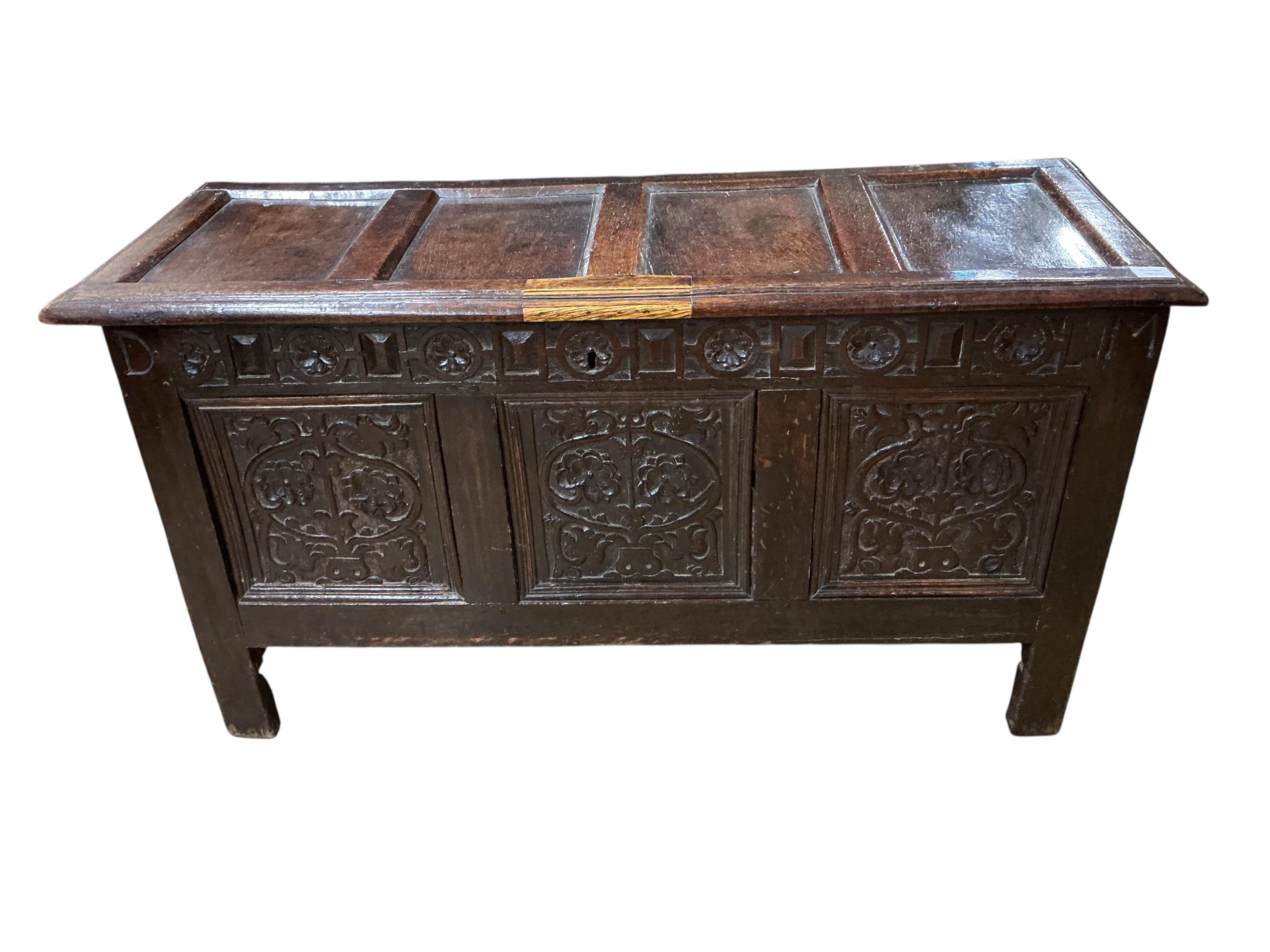 A late 17th century carved oak triple panelled coffer, the top rail monogrammed D.M, width 128cm, depth 48cm, height 68cm